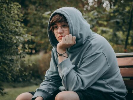 Young mans Portrait in Hooded Clothing with a Sad Expression. Grieving man wears hooded clothing, displaying sadness and sorrow.