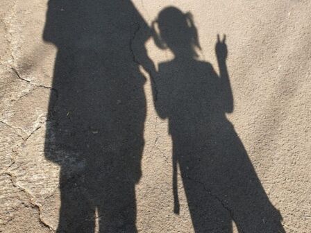 shadow of mom and daughter who going to school.