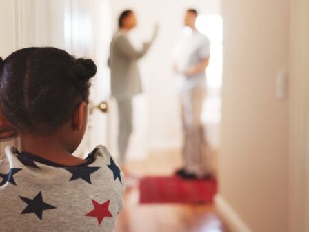 Divorce, fight and back of child in family home for conflict, disagreement and custody battle. Relationship crisis, frustrated and anger with kid watching parents in hallway of house for break up