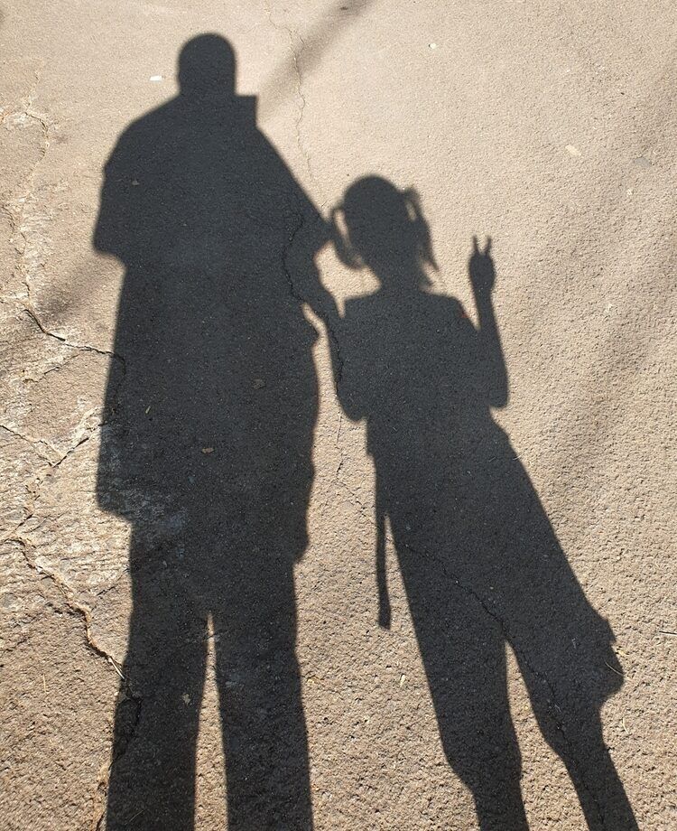 shadow of mom and daughter who going to school.